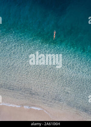 Donna galleggianti in mare, Gili Air, isole Gili, Indonesia Foto Stock