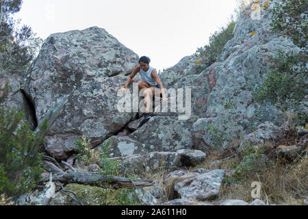 Giovane donna asiatica di arrampicata in una parete di roccia Foto Stock