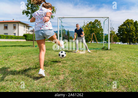 Padre e figlia a giocare a calcio su un prato Foto Stock