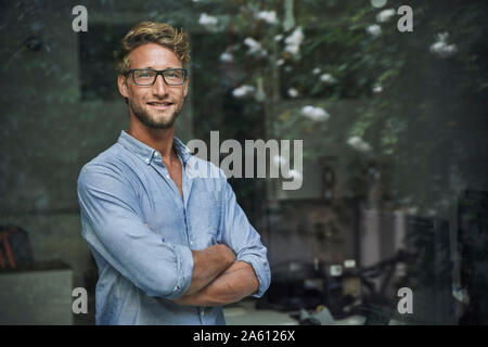 Ritratto di giovane casual uomo d affari dietro il vetro di finestra di office Foto Stock