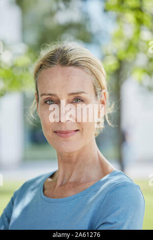 Ritratto di fiducioso donna bionda in un parco Foto Stock