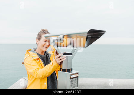 Giovane donna bionda guardando attraverso il telescopio Foto Stock