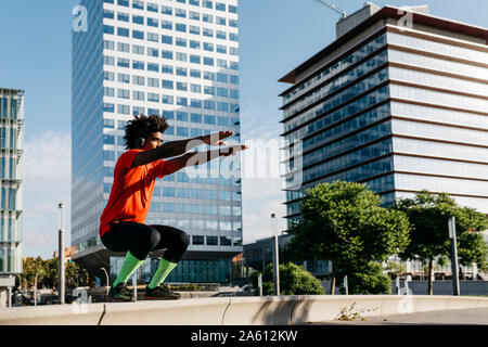 Giovane uomo facendo sport, ginocchio si piega Foto Stock