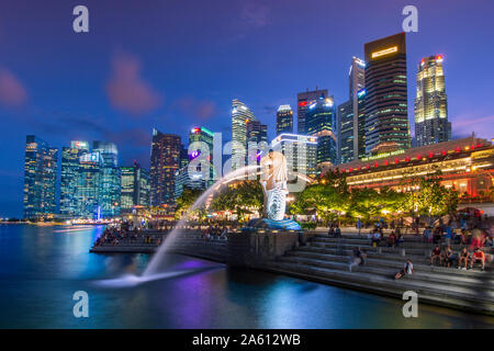 Il Merlion di Marina Bay con il Fullerton Hotel set contro il quartiere finanziario di notte, Singapore, Sud-est asiatico, in Asia Foto Stock
