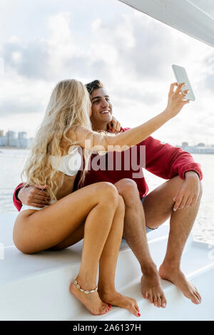 Coppia giovane godendo una giornata estiva su una barca a vela Foto Stock