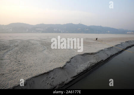 Pre-alba cast off, uomo rilasciando corde da un ormeggio in sabbia fine di un sandspit stagionale nel fiume Brahmaputra, Assam, India, Asia Foto Stock