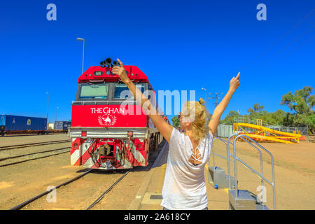 Alice Springs, Territorio del Nord, Australia - 29 AGO 2019: happy tourist donna con braccia sollevate nella parte anteriore del treno Ghan lusso treno passeggeri a Alice Foto Stock