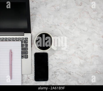 Vista superiore della moderna area di lavoro elegante ufficio con computer portatile, caffè, telefono e Blocco note Foto Stock