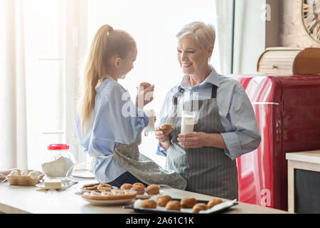 Gentile ragazza e la nonna di conversazione mentre ora di pranzo Foto Stock