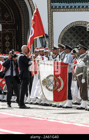 Cartagine, Tunisia. 23 Ott, 2019. Kais Saied (2 L) bacia la bandiera Tunisina al momento del suo arrivo al palazzo di Cartagine dopo il suo giuramento in occasione della cerimonia in cui egli prese un giuramento come la Tunisia è di nuovo presidente. Credito: Khaled Nasraoui/dpa/Alamy Live News Foto Stock