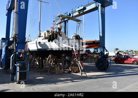 Imbarcazione a vela in procinto di essere spostata da un travel lift a Aguadulce marina boat yard, Aguadulce, Almeria, Spagna Foto Stock