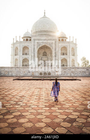 Donna in abito tradizionale guardando il Taj Mahal, Agra, India Foto Stock