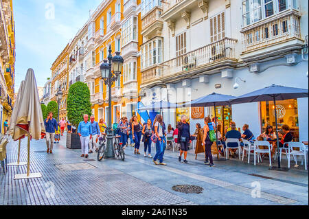 CADIZ, Spagna - 19 settembre 2019: l'ombra stretta calle Nueva (New Street) è uno dei luoghi più popolari in città vecchia per il resto nella terrazza esterna Foto Stock