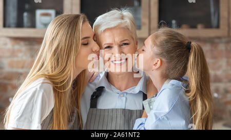 Ritratto di mamma e figlia di baciare la nonna Foto Stock