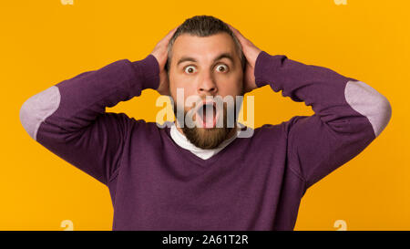Sorpreso storditi emotional man, con le mani sulla testa Foto Stock