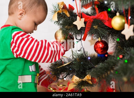 Adorable baby boy decorare albero di Natale a casa Foto Stock