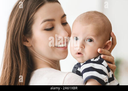 Ritratto di Madre bella abbracciando il suo bambino neonato Foto Stock