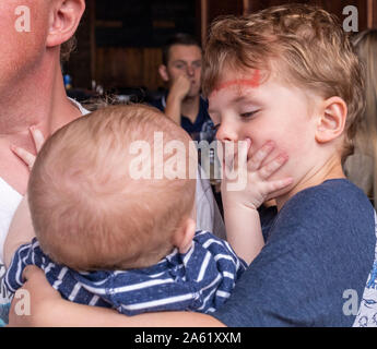 Detroit, Michigan - Uno-anno-vecchio Jimi Hendrix Hjermstad tormenti del fratello, Adam Hjermstad Jr., 5, durante il pranzo in un ristorante. Foto Stock