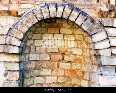 Arrotondato in cotto antico. Frammento di muratura nel monastero. Foto Stock