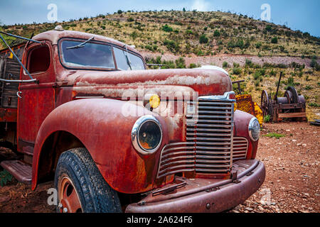 Grande vecchio arrugginito pickup truck marciume fuori in un campo. Foto Stock