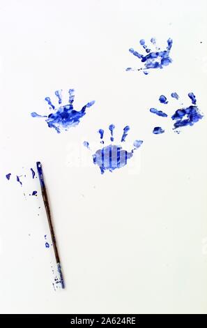 Un bambino piccolo handprint in vernice blu su sfondo bianco Foto Stock