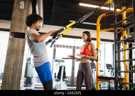 Istruttore di Fitness esercizio con client presso la palestra. Foto Stock