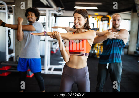 Montare belle persone che lavorano in palestra insieme Foto Stock
