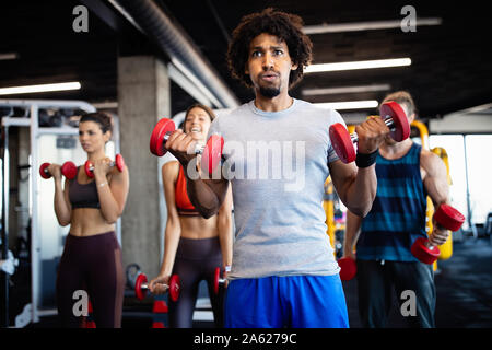 Salutare i giovani a fare gli esercizi in palestra per il fitness. Foto Stock