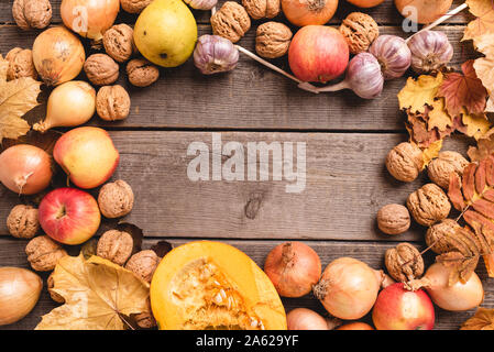 In autunno la disposizione dei raccolti stagionali con foglie colorate. Vista superiore della verdura e frutta. Composizione intorno al telaio con un centro libero. Foto Stock