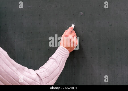 Maestro sta con il gesso sulla lavagna Foto Stock