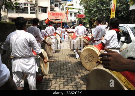 Mumbai, Maharashtra, India, Sud-est asiatico : devoti indiani giovani ragazzi e ragazze suonare il tamburo tradizionale o dhol con memory stick durante Ganpati visarjan Foto Stock