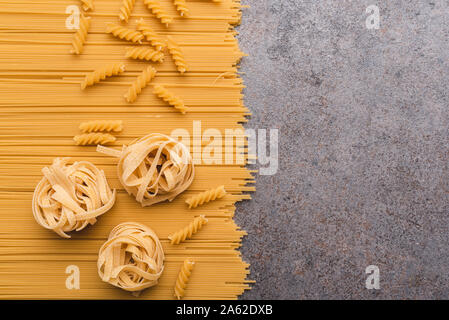 Diversi tipi di pasta che usiamo ogni giorno in cucina durante la cottura. Vista da sopra. Prodotti pianeggiante. Il luogo di una descrizione o di un testo. Foto Stock