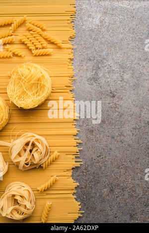Diversi tipi di pasta che usiamo ogni giorno in cucina durante la cottura. Vista da sopra. Prodotti pianeggiante. Il luogo di una descrizione o di un testo. Foto Stock