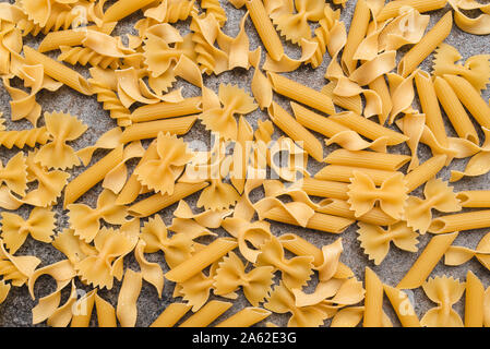 Diversi tipi di pasta che usiamo ogni giorno in cucina durante la cottura. Vista da sopra. Prodotti pianeggiante. Il luogo di una descrizione o di un testo. Foto Stock