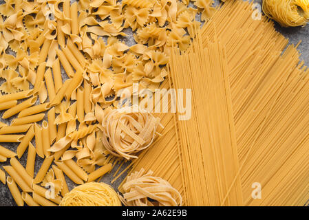 Diversi tipi di pasta che usiamo ogni giorno in cucina durante la cottura. Vista da sopra. Prodotti pianeggiante. Il luogo di una descrizione o di un testo. Foto Stock