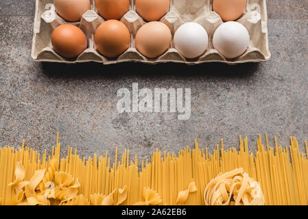 Diversi tipi di pasta e uova che usiamo ogni giorno in cucina durante la cottura. Vista da sopra. Prodotti pianeggiante. Posto per una descrizione. Foto Stock