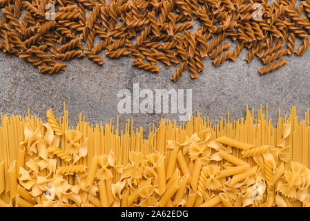 Diversi tipi di pasta che usiamo ogni giorno in cucina durante la cottura. Vista da sopra. Prodotti pianeggiante. Il luogo di una descrizione o di un testo. Foto Stock