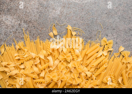 Diversi tipi di pasta che usiamo ogni giorno in cucina durante la cottura. Vista da sopra. Prodotti pianeggiante. Il luogo di una descrizione o di un testo. Foto Stock