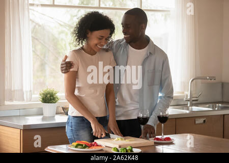 Gioiosa felice americano africano sposa la cucina insieme in cucina. Foto Stock