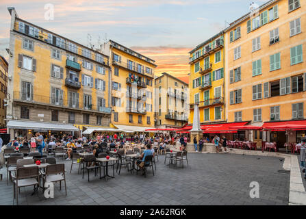 I turisti e i locali godono di un inizio serata presso il cafè, fontana di acqua e negozi al posto di Rossetti, una delle piazze principali di Vieux Nice Francia Foto Stock