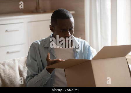 Deluso giovane americano africano client maschio acquirente ricevuto oggetto danneggiato. Foto Stock