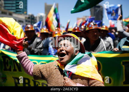 La Paz in Bolivia. 23 Ott, 2019. Una donna sventolare la bandiera della Bolivia e gridando slogan politici in un rally a sostegno del Presidente Morales. Affermazioni contraddittorie da parte di elezione autorità per quanto riguarda il conteggio delle elezioni presidenziali hanno provocato proteste dell opposizione. Capo di stato Morales ha detto che vi è stato un tentativo di colpo di stato in corso. Credito: Gaton Brito/dpa/Alamy Live News Foto Stock