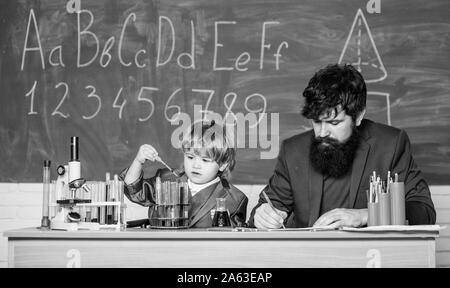 Formula. esperimenti in organic chemistry laboratory. piccolo ragazzo con insegnante l'uomo. La sapienza. Si torna a scuola. il figlio e il padre a scuola. la ricerca nel campo delle biotecnologie concetto. Istruzione impegna un uomo Foto Stock