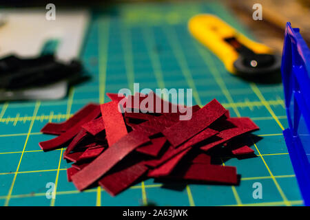 Un mucchio di rosso le strisce di cuoio su una griglia tappetino di artigianato Foto Stock