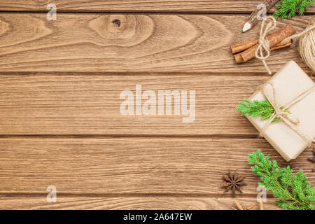 Realizzato a mano DIY regalo di Natale scatola su uno sfondo di legno. Presente naturale scatole per Natale e Capodanno o altro anniversario. Biglietto di auguri con copia sp Foto Stock