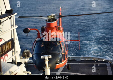 Un elicottero di interdizione squadrone tattico equipaggio elicottero atterra sul ponte di volo del guardacoste vigile mentre di pattuglia dei Caraibi. L'EQUIPAGGIO SORVEGLIANO incentrato su enforcing U.S. leggi federali mediante conduzione di fermi di pescherecci internazionali in tutto il bacino dei Caraibi, mentre si lavora con altre agenzie governative e partner internazionali, per aumentare la sicurezza nazionale. (U.S. Coast Guard foto di alfiere speranza DuBois) Foto Stock