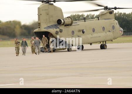 Un gruppo di soldati e aviatori dall'Iowa Guardia Nazionale forze congiunte sede a piedi fuori da un U.S. Esercito CH-47 elicottero Chinook assegnato alla società di Bravo 2° 211 Aviation Support Facility di Davenport, Iowa a Sioux City, Iowa Air National Guard il 23 ottobre 2019. Il gruppo è con il Mag. Gen. Ben Corell l'Aiutante Generale dell'Iowa National Guard per chi visita il 185th Air Refuelling ala nella città di Sioux in ordine al banco dell'aria impianto di protezione. Stati Uniti Air National Guard foto di Senior Master Sgt. Vincent De Groot Foto Stock