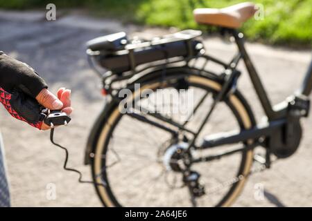 Ciclista pronti per collegare la batteria su una bicicletta elettrica, Belgio Foto Stock