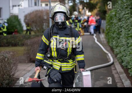 Vigile del fuoco con una maschera di protezione delle vie respiratorie in azione, Stoccarda, Germania Foto Stock