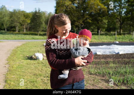 Il contadino e il suo bambino a giardino ecologico Foto Stock